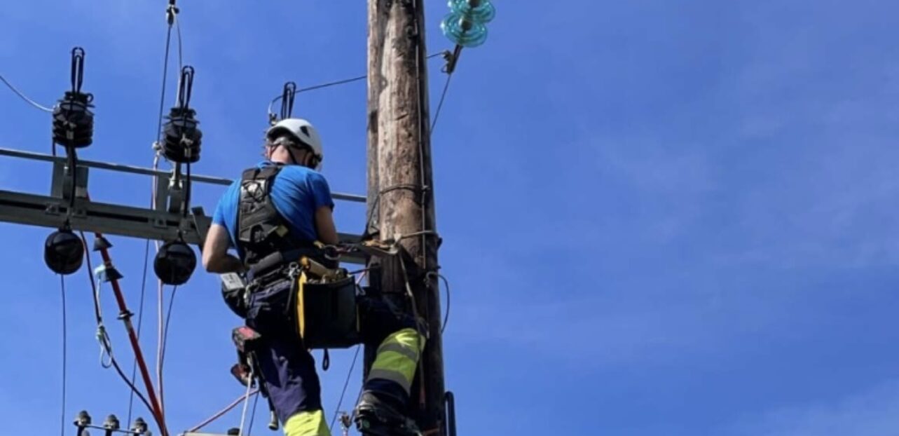 Foto av montør som arbeider i høyspentmast