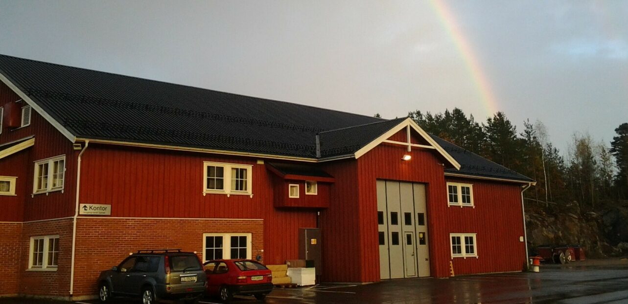 Bilde av DE Netts lokaler fra utsiden med regnbue på himmelen